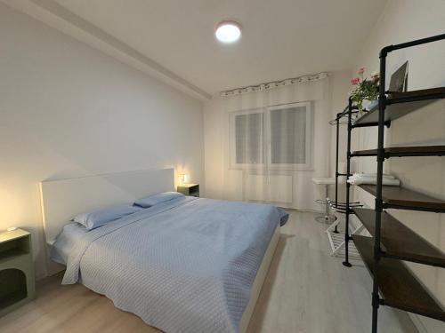 a white bedroom with a bed and a window at The Desdemona in Pordenone