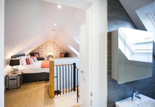 a bedroom in a loft with a bed and a sink at Glenmoriston Town House Apartments in Inverness