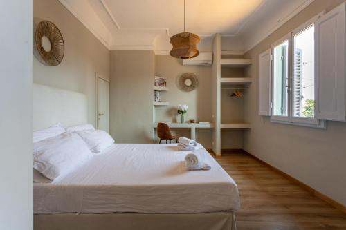 a bedroom with a large white bed and a window at Bohemian Palace Florence in Florence
