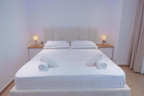 a bedroom with a large white bed with towels on it at Seaview Premium Apartment in Durrës