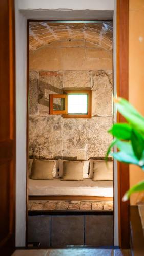 a small bed in a stone wall with a window at Agroturisme Son Cardaix in Artá