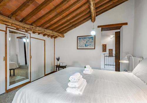 a bedroom with a bed with towels on it at Vicinato Homestead in Molazzana