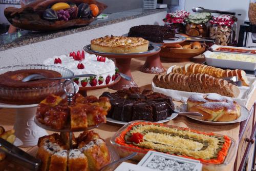 a table with many different types of cakes and pastries at Hotel Kima in Bombinhas