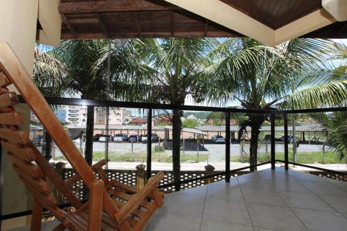 a porch with a view of a palm tree at Hotel Kima in Bombinhas