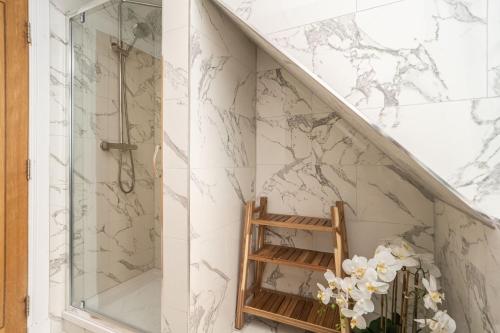 a bathroom with marble walls and a glass staircase at A beautiful mews house in a city centre in Edinburgh
