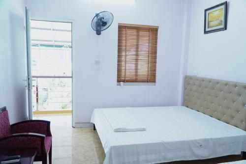 a white room with a bed and a window at Ngày Mới Hotel in Nghĩa Lộ