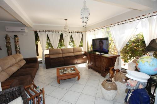 a living room with a couch and a television at Hotel Kima in Bombinhas
