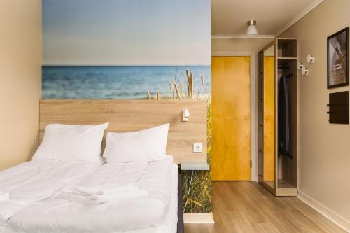 a bedroom with a bed with a view of the ocean at Scandic Sørlandet in Kristiansand