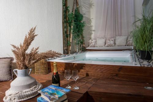 a bath tub with two glasses of wine and a table at Atlantis Boutique City Hotel in Rhodes Town