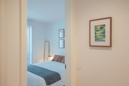 a bedroom with a bed and a picture on the wall at Aposentus - Sal D 'Ouro Exclusive in Canidelo