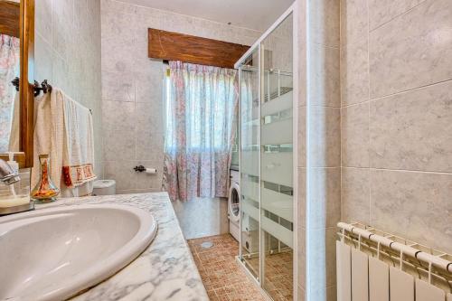 a bathroom with a tub and a glass shower at La Adrada Green Escape with pool in La Adrada