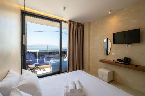 a hotel room with a bed and a large window at Heavenly Rest Luxury Hotel in Sarandë