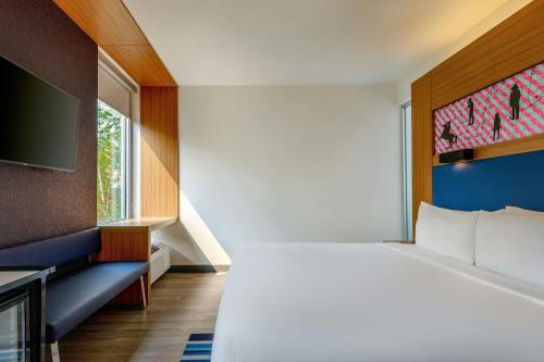 a hotel room with a bed and a tv at Aloft by Marriott Lexington in Lexington