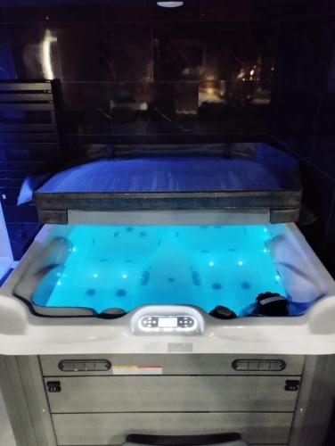 a hot tub with blue water in a room at L'Échappée Romantique & Spa Privatif in Foix