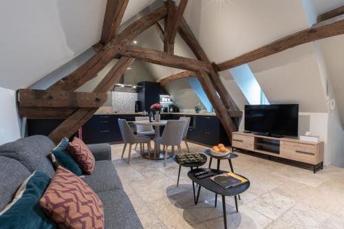 a living room with a couch and a tv at Escale de Giulia in Beaune