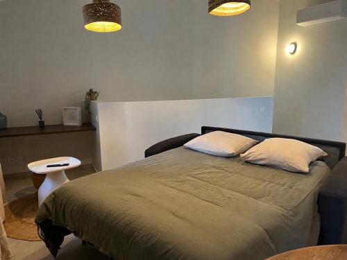 a bedroom with a bed with two pillows on it at Chez Elsa et Camille in Aigues-Mortes