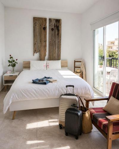 a bedroom with a bed with a suitcase and a couch at PanMari in Paphos