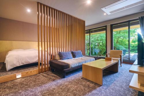 a bedroom with a bed and a couch and a table at Onyado Satsuki in Tamana