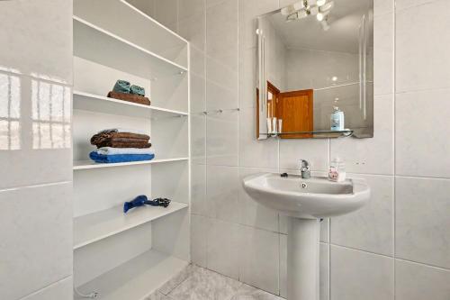 a white bathroom with a sink and a mirror at Villa Gabriela in Tarajalejo