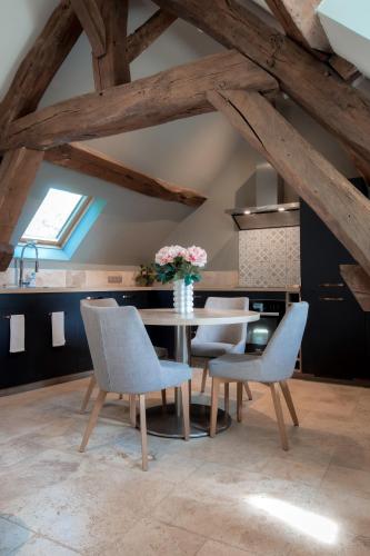 a dining room table with chairs and a vase of flowers at Escale de Giulia in Beaune