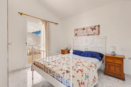 a bedroom with a white bed and a window at Villa Gabriela in Tarajalejo