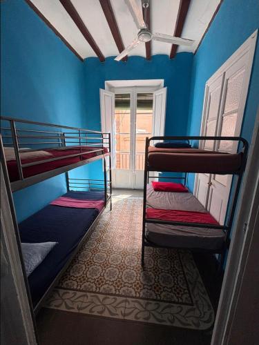two bunk beds in a room with blue walls at Tarragona Rooms 4 in Tarragona