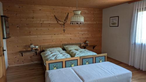 a bedroom with a bed and a wooden wall at Ferienhaus Buchen in Schwarzenberg