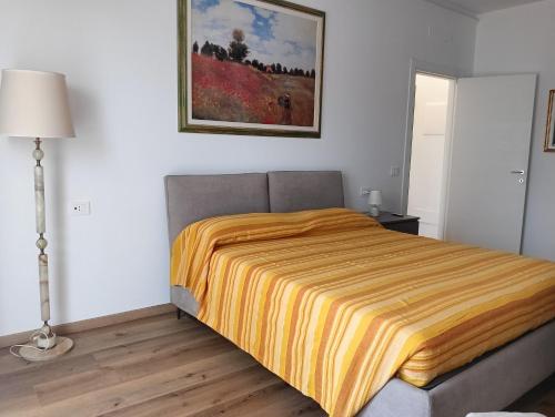 a bedroom with a bed with a yellow blanket on it at Il Lago di Luciana in Intra