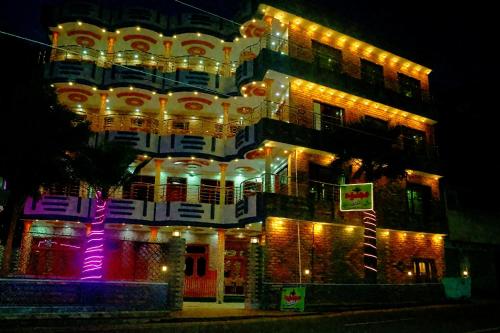 a large building with lights on it at night at Ajwah Hotel Bahrain in Āīn