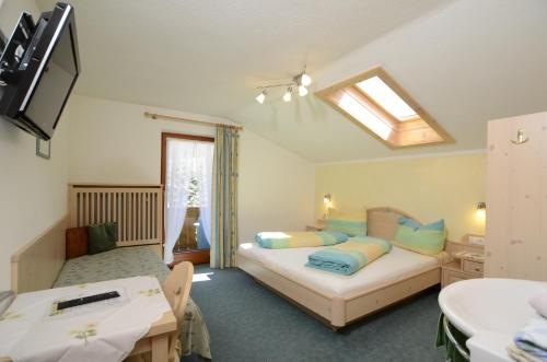 een slaapkamer met een bed en een dakraam bij Apart Haus Wachter in Pfunds