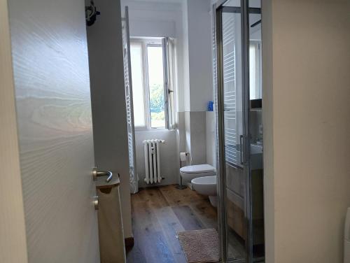 a bathroom with a toilet and a glass door at Il Lago di Luciana in Intra