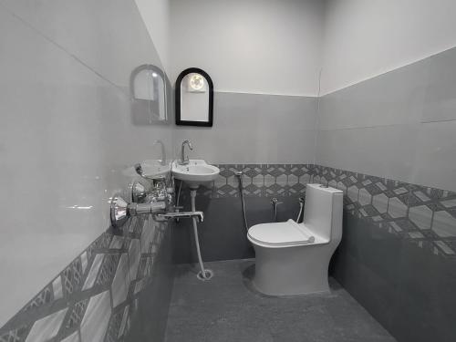 a bathroom with a toilet and a sink at Pahadi aangan in Bhīm Tāl