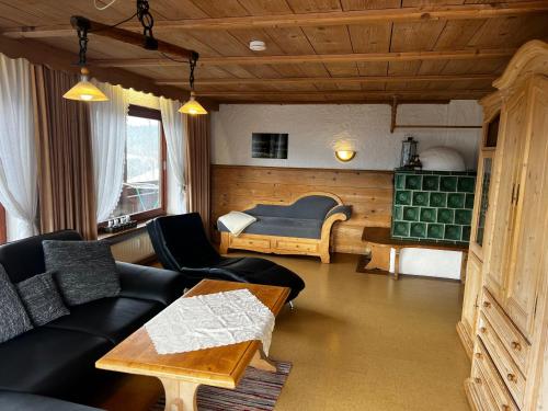 a living room with a couch and a bed at Landhaus Alpenstern in Riezlern