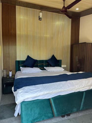 a bedroom with a large bed with blue and white sheets at Pahadi aangan in Bhīm Tāl