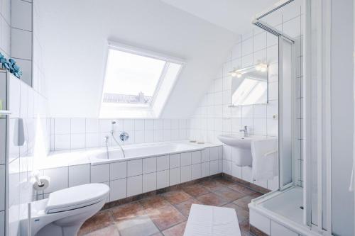 a bathroom with a tub and a toilet and a sink at Rauchschwalbe in Zingst