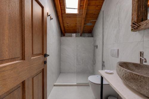 a bathroom with a shower and a toilet and a sink at Vila Harmoni Roshnik in Roshnik