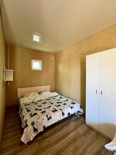 a bedroom with a bed with a white comforter at Hotel Yuzhanka in Sanzhiyka