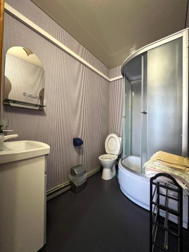 a bathroom with a tub and a toilet and a sink at Hotel Yuzhanka in Sanzhiyka