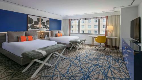 a hotel room with two beds and a tv at The Royal Sonesta Washington DC Dupont Circle in Washington, D.C.