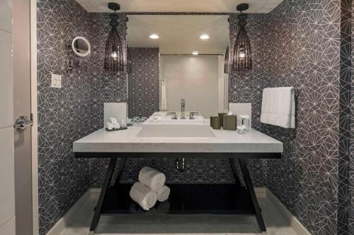 a bathroom with a sink and a large mirror at The Royal Sonesta Washington DC Dupont Circle in Washington, D.C.