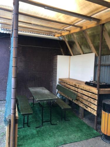 a picnic table and two benches under a roof at Дом in Borovoye