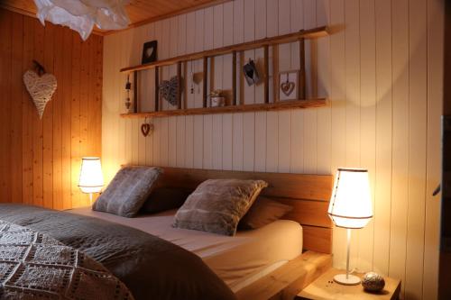 a bedroom with a bed with two lamps and a shelf at Meine kleine Ecke in Ferden