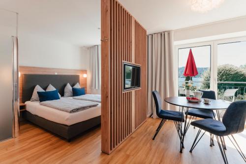 a hotel room with a bed and a table and chairs at Echo am See in Gmunden