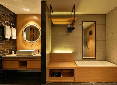 a bathroom with a tub and a sink and a mirror at Orange Hotel Beijing Shangdi Huandao in Beijing