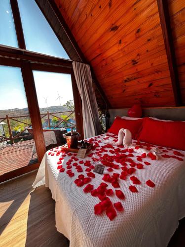 a bedroom with a bed covered in red rose petals at Cabanas Bouganville in Monte das Gameleiras