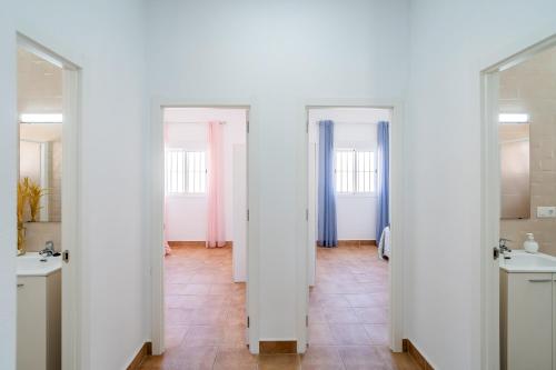 a bathroom with two sinks and two mirrors at Casa Rural Rafael in La Lantejuela