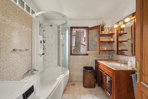 a bathroom with a tub and a shower and a sink at Private Pool And Ocean Views in Chayofa