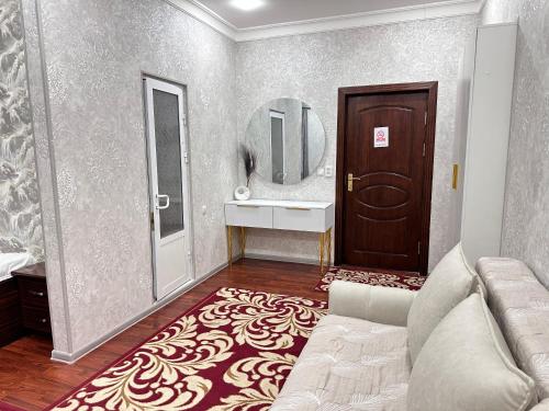 a bathroom with a couch and a sink and a mirror at Marvarid Hotel in Ghijduwon