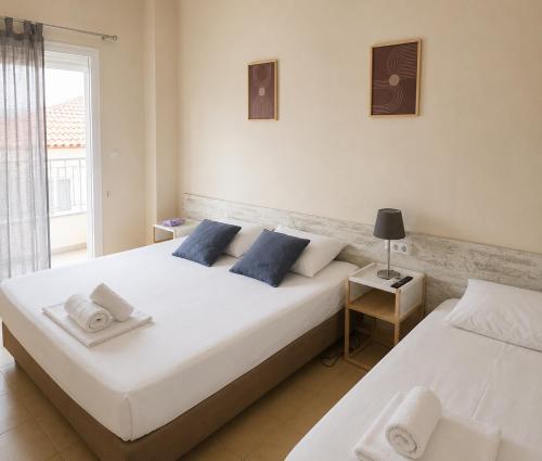 a bedroom with two beds and a window at Meltemi Studios Polychrono in Polychrono
