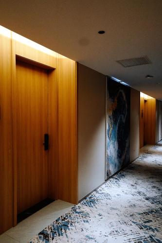 a hallway with wooden doors and a painting on the wall at Bishkek Crystal Luxury Smart Hotel Ala-Too Square Branch in Bishkek